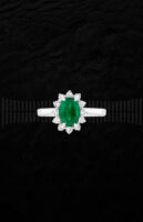 Anillo de oro blanco con esmeralda central rodeada de diamantes