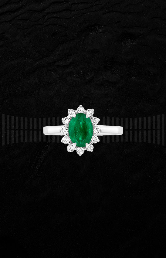 Anillo de oro blanco con esmeralda central rodeada de diamantes